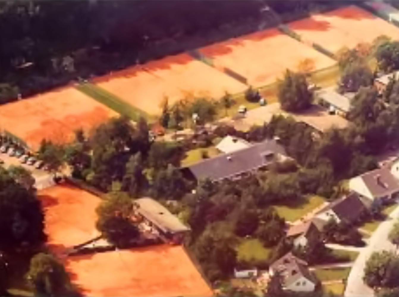 Eine Gruppe von Menschen in Sportkleidung, einige halten Tennisschl&auml;ger.